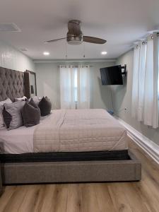 1 dormitorio con 1 cama grande y TV de pantalla plana en Cozy Home in a Golf kart neighborhood and private pool en Palm Harbor