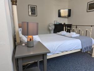 um quarto com uma cama e uma mesa com um candeeiro em Dover Town Rooms - Short Lets & Serviced Accommodation - Dover em Dover