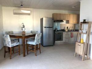 a kitchen with a table and a stainless steel refrigerator at Local Home Aruba in Catiri