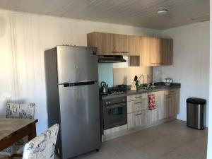 a kitchen with a stainless steel refrigerator and wooden cabinets at Local Home Aruba in Catiri