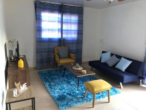 a living room with a blue couch and a blue rug at Local Home Aruba in Catiri