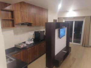 a kitchen with a tv and wooden cabinets at Urban Boutique Hotel Pokhara in Pokhara