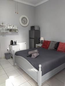 una camera da letto con un letto con un orologio sul muro di 21on2nd Avenue a Tzaneen