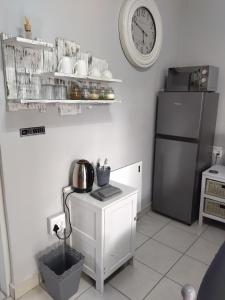 a kitchen with a refrigerator and a clock on the wall at 21on2nd Avenue in Tzaneen