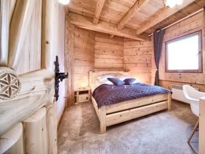 コシチェリスコにあるVisitZakopane - Waterfall SPA Apartmentの木造キャビン内のベッド1台が備わるベッドルーム1室を利用します。