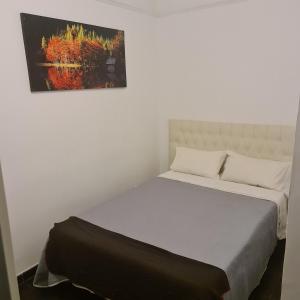 a bed in a room with a painting on the wall at Rooms Moncloa in LOFT - TPH Madrid in Madrid