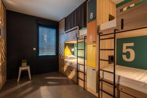 Cette chambre comprend des lits superposés avec une table et un tabouret. dans l'établissement Whoo Bordeaux Bacalan - Hostel, à Bordeaux