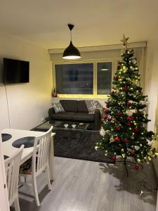a living room with a christmas tree in it at City Center Apartment in Rovaniemi