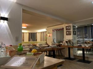 eine Küche und ein Wohnzimmer mit Tischen und einem Sofa in der Unterkunft Hotel Montana in De Panne