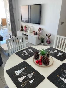 A television and/or entertainment centre at Ocean Garden Sunset Apartment - heated swimming pool Free WIFI