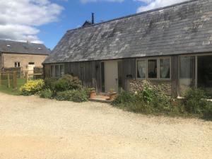 a house with a gray roof and a yard at Clematis cottage in Cheltenham