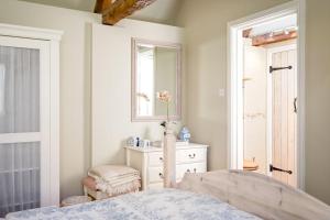 a bedroom with a bed and a sink and a mirror at Clematis cottage in Cheltenham