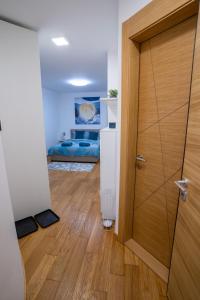 Habitación con puerta de madera y dormitorio en Sky Apartments Novi Sad en Novi Sad