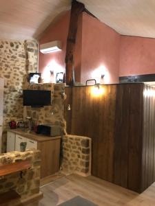 a kitchen with pink walls and a stone wall at Chez Marinou in Chirols