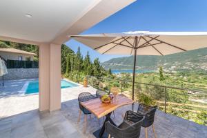 un patio con una mesa y una sombrilla en Villa Gyri, en Vasiliki