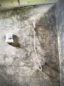 a room with a hose attached to a wall at Frog Garden Hut in Ko Phayam