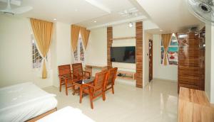 - une chambre avec un lit, une table et des chaises dans l'établissement Sree Bharat Residency, à Alāndurai