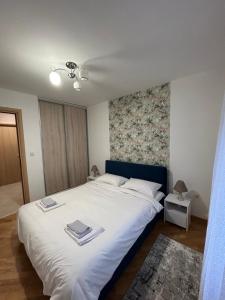 een slaapkamer met een wit bed met twee boeken erop bij Vert Apartment in Banja Luka