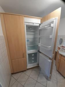 an empty refrigerator in a kitchen with its door open at TannenQuartier - Ihr Ferienhäuschen in Groß Grönau