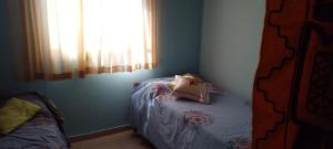 Habitación pequeña con cama con almohada. en casa de ensueño en La Falda