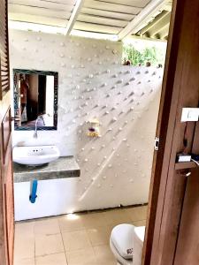 a bathroom with a sink and a mirror at Frog Garden Hut in Ko Phayam