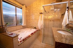 a bathroom with a tub and a sink and a shower at Hospedaria Recanto da Val in Passa Quatro