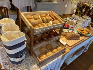 una mesa cubierta con bandejas de bollería y otros alimentos en Landhaus Marinella Hotel Garni en Bad Wiessee