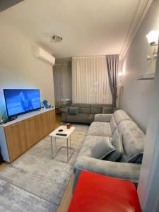 ein Wohnzimmer mit einem Sofa und einem Flachbild-TV in der Unterkunft Kendi evinize hoşgeldiniz in Istanbul