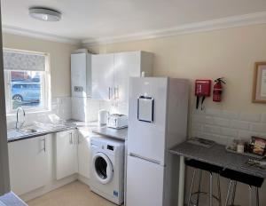 a kitchen with a refrigerator and a washing machine at 2 Brunswick Terrace in Sandown