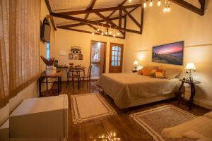 1 dormitorio con 1 cama y sala de estar en Hospedaria Recanto da Val, en Passa Quatro