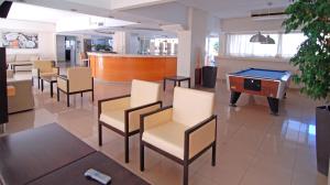 um quarto com cadeiras e uma mesa de bilhar em Michel Apartments em Cidade de Kos