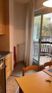 a kitchen with a table and a view of a balcony at Monolocale Artesina sci ai piedi in Sella della Turra
