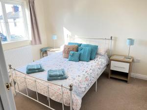 a bedroom with a bed with blue pillows on it at 2 Brunswick Terrace in Sandown