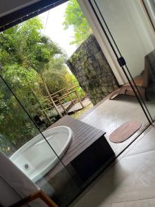 a bath tub sitting inside of a room with a window at Pousada Morro dos Navegantes in Ilhéus