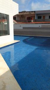 una gran piscina azul junto a un edificio en Praia dos Carneiros Flat Hotel Lindo Apto 302 en Praia dos Carneiros