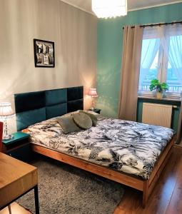 1 dormitorio con cama, mesa y ventana en 2-Room Apartment, en Nowy Dwór Mazowiecki