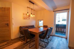 a dining room with a wooden table and chairs at Haus Michael Tritscher in Schladming