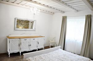 Baño blanco con lavabo y espejo en R Cottage Jacuzzival en Balatonfenyves