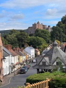 a small town with a castle in the background at Woodville Barn in Dunster