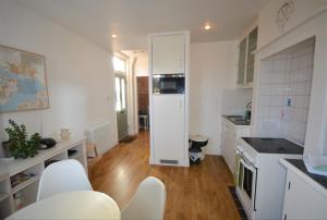 a kitchen with white appliances and white cabinets at 20 Bellevue Road in Ryde