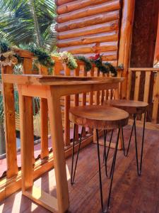 una mesa de madera y dos taburetes en un porche en Elfen hospedaje familiar, en Oxapampa