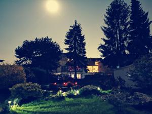 ein Haus inmitten eines Gartens mit Bäumen in der Unterkunft Home Inn Hotel in Dormagen