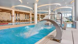 a swimming pool with a water slide in a building at Apartament Lux Tukan B005 Polanki Aqua - Holiday City in Kołobrzeg