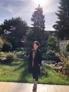 una donna in piedi su un vialetto in un giardino di Home Inn Hotel a Dormagen