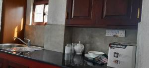 a kitchen counter with a sink and a refrigerator at SEVENTY SEVEN GALLE in Galle