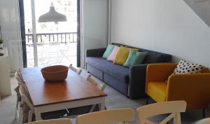 un soggiorno con divano, tavolo e sedie di Ocean and pool view - Apartamento Parque Santiago 2 ad Arona