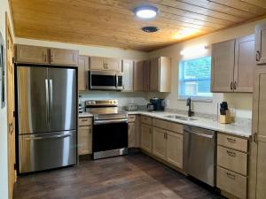 uma cozinha com utensílios de aço inoxidável e armários de madeira em High Valley Apartments em Pigeon Forge
