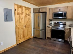 a kitchen with stainless steel appliances and wooden cabinets at High Valley Apartments in Pigeon Forge