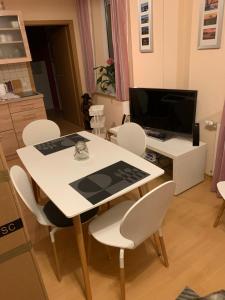 a white table and chairs in a kitchen with a television at Kathrin`s Appartment in Oelsnitz