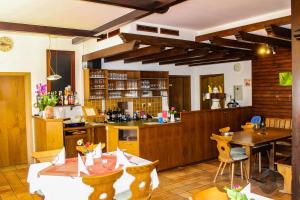 eine Küche mit einem Tisch, Stühlen und einer Theke in der Unterkunft Beny Hotel Restaurant in Bad Bellingen